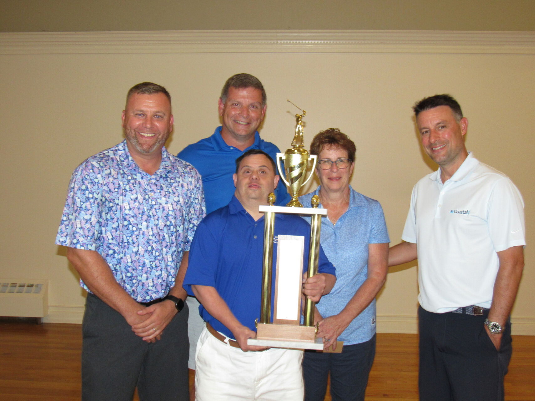 attendees at community event posing for picture with trophy